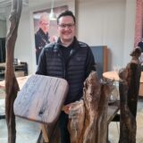 Justin Wiemann in der Werkstatt Havixbeck mit verarbeitetem Holz
