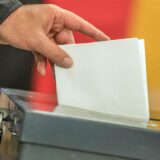Ein Mann wirft einen Wahlzettel in eine Wahlurne