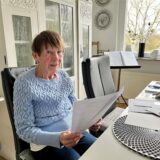 Reinhild Schmidt hält die Unterlagen in der Hand.