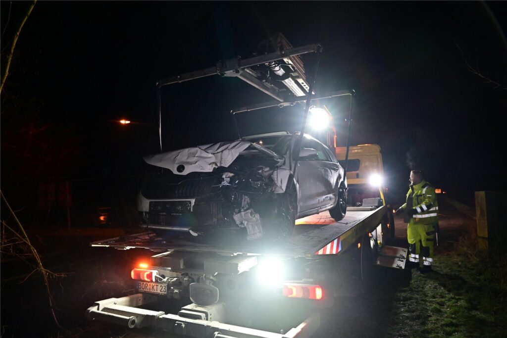 Ein Unfallfahrzeug steht auf der Ladefläche eines Abschleppwagens.