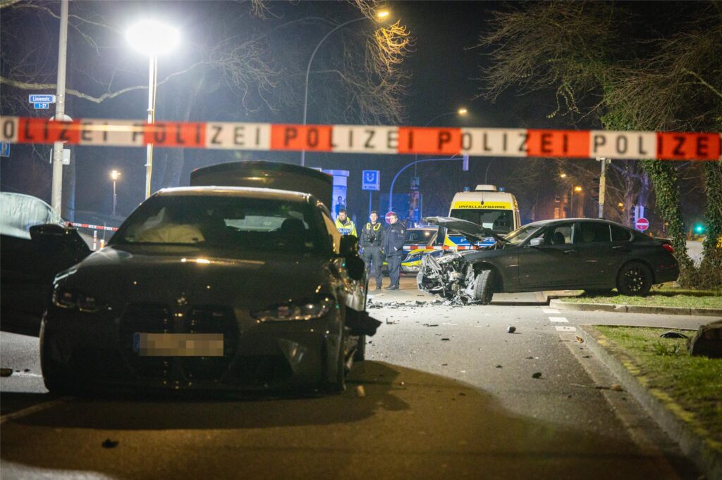 Zwei beschädigte BMW nach einem Unfall stehen auf einer Straße.