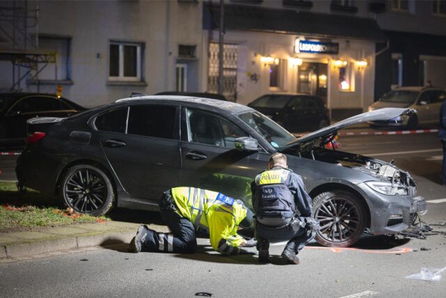 Polizisten der Verkehrsunfallaufnahme untersuchen eine Unfallstelle.