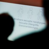 Zwei Menschen im Schatten blicken auf ein Blatt Papier