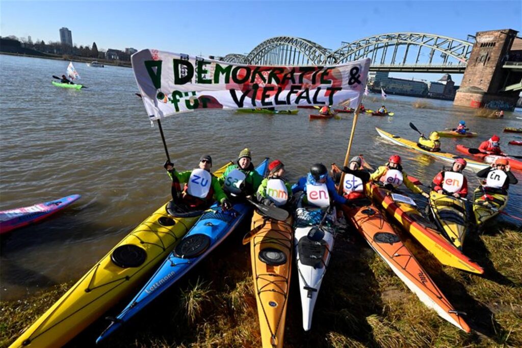 Premiere in Köln: Auf dem Rhein demonstrieren Wassersportler für Demokratie und Vielfalt.