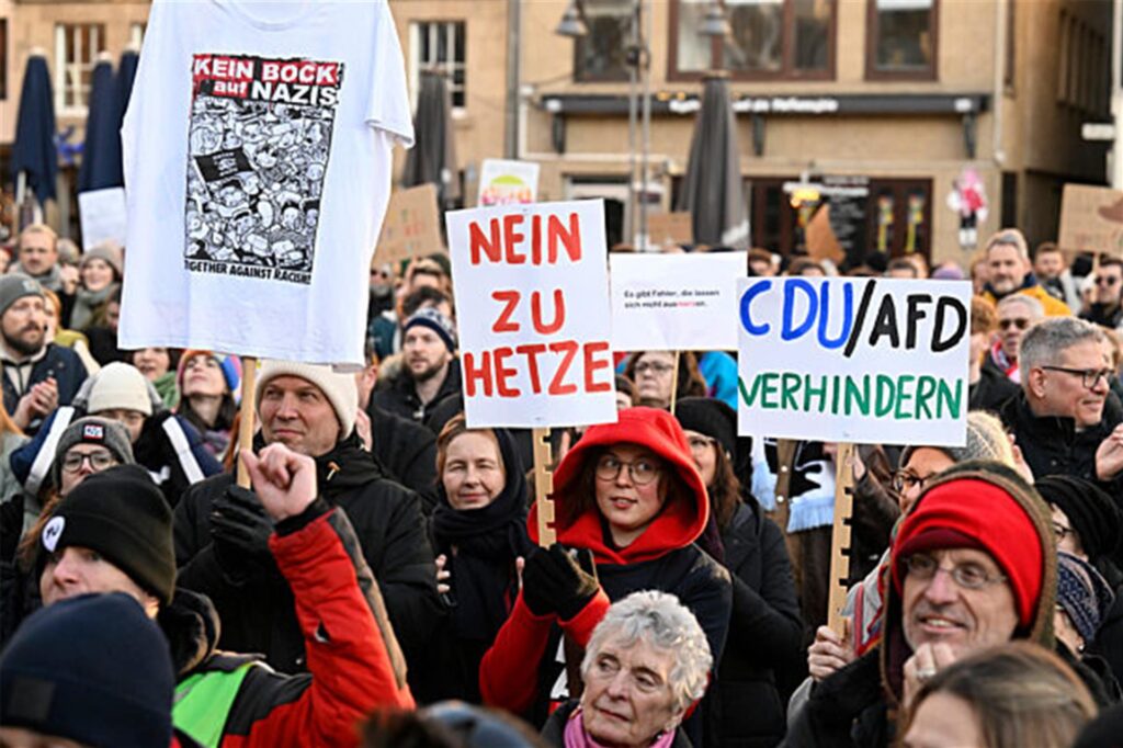 Demonstranten in Köln protestieren gegen das Verhalten der CDU zum Thema Migration.