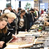 Mehrere Menschen studieren die Auslage bei einem Trödelstand im Marler Stern. Auf dem Tisch liegen Kassetten mit Schmuck. Man erkennt Ringe und Ketten. Im Hintergrund ist der Ausgang Richtung Rathaus zu sehen.