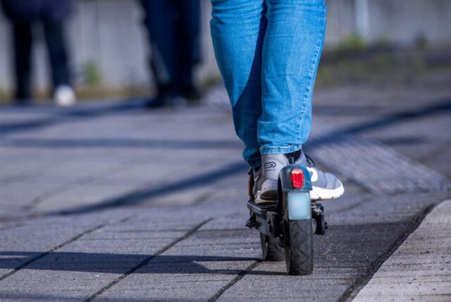 Jemand fährt auf einem E-Scooter.