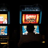 Die Silhouette eines Mannes vor einem bunt leuchtenden Spielautomaten