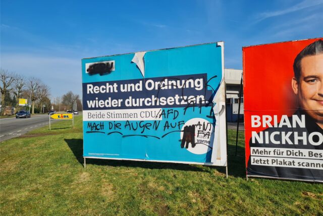 Ein großes CDU-Wahlplakat an der Münsterstraße ist beschmiert. Zu erkennen ist ein Schriftzug der Antifa.