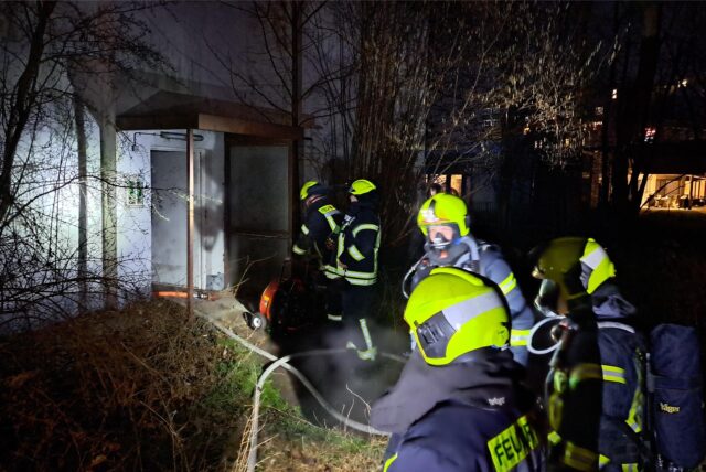 Feuerwehrleute gehen in ein Gebäude, in dem es brennt.
