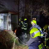 Feuerwehrleute gehen in ein Gebäude, in dem es brennt.