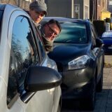 Nadine Weber-Mau und Michael Schiller schauen auf der engen Gartenstraße in Herten-Mitte zwischen parkenden Autos hindurch, ob die Fahrbahn frei ist.