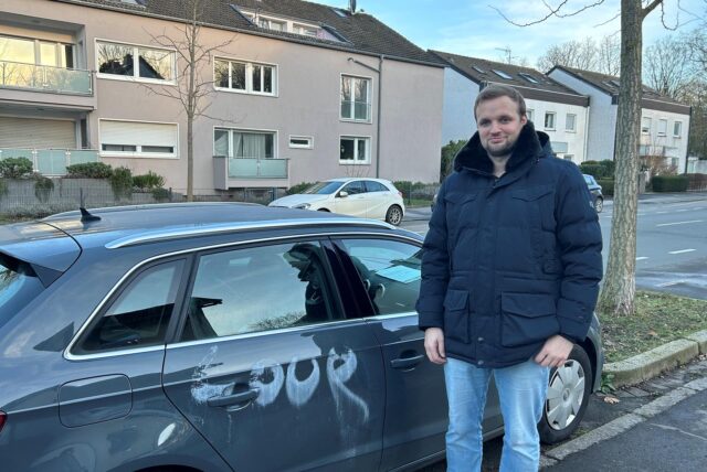 Hauke Schultz steht in Dortmund neben seinem Audi, der mit weißer Farbe besprüht wurde.