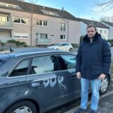 Hauke Schultz steht in Dortmund neben seinem Audi, der mit weißer Farbe besprüht wurde.