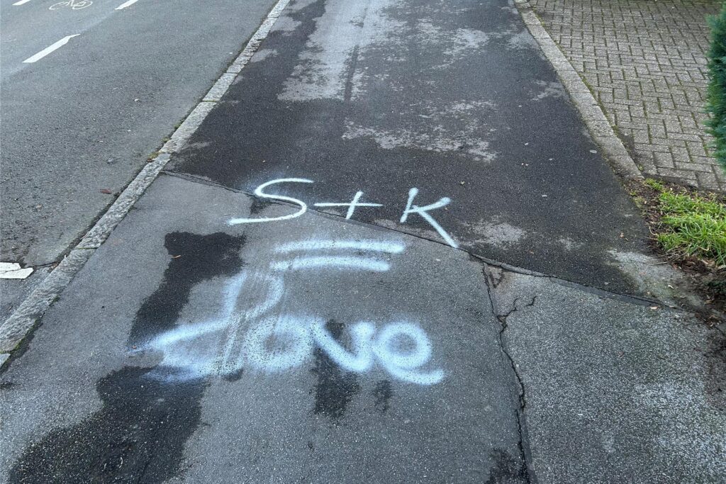 Weißer Schriftzug auf einem Gehweg: Weißer Schriftzug auf einem Gehweg: