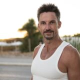 Mark Lewandowski – Teilnehmer bei GNTM 2025 – steht im Tanktop vor der Kamera und lächelt leicht.