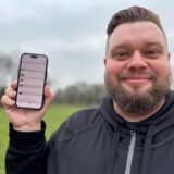 Malte Salmen hält im Park in Waltrop sein Handy in der Hand und zeigt eine Sprachlern-App