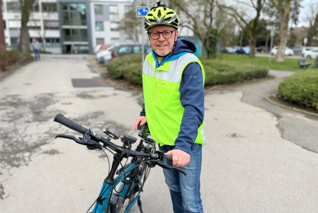 Burkhard Tiessen steht neben seinem Fahrrad.