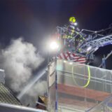 Ein Feuerwehrmann löscht über eine Drehleiter einen Dachstuhlbrand in Marl-Hüls.