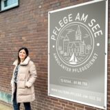 Laura Burrichter vor dem neuen Geschäftslogo Pflege am See
