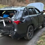 Ein schwarzer Kombi mit eingedrücktem Kofferraum nach einem Unfall