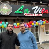 Zwei Männer stehen vor der Pizzeria.