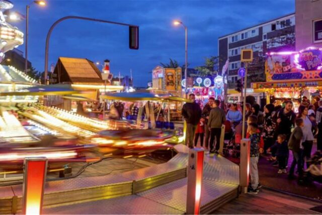 Besucher auf der Karnevalskirmes in Bottrop zwischen Fahrgeschäften.