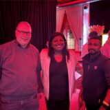Boris Aleff, Gajana und Prasath Punniyamoorthy stehen nebeneinander in der La Victoria Halle in Marl. Die Beleuchtung ist sehr rot.