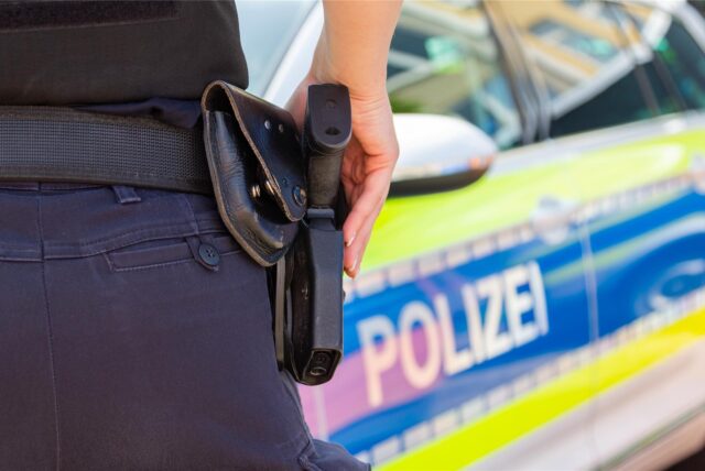 Ein Polizist vor einem Polizeiauto
