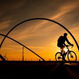 Ein Radfahrer vor dem Hintergrund des Sonnenuntergangs am Horizont-Observatorium.