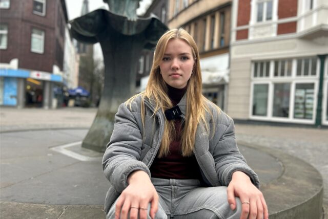 Anna Degener sitzt auf dem Brunnen am Antoniusdenkmal in Herten-Mitte.