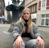 Anna Degener sitzt auf dem Brunnen am Antoniusdenkmal in Herten-Mitte.
