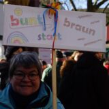 Eine Frau hält ein Plakat mit der Aufschrift „bunt statt braun“