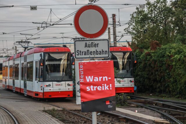Vor zwei Stadtbahnen hängt ein Streikschild. (Symbolbild)