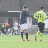 Die Spieler des TuS Harpen genehmigen sich eine Verschnaufpause während im Hintergrund Timo Schmidt behandelt wird.