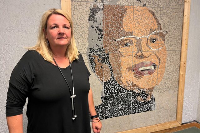 Stephanie Brzoza, Leiterin der Rosa-Parks-Gesamtschule Herten, vor einem großen Portrait der Namensgeberin der Schule.