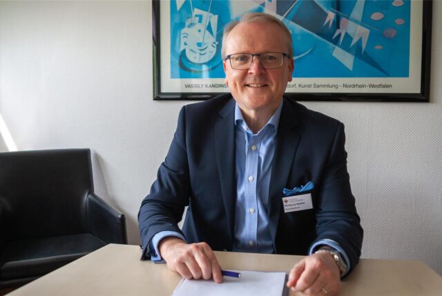 Wolfgang Mueller sitzt am Schreibtisch.