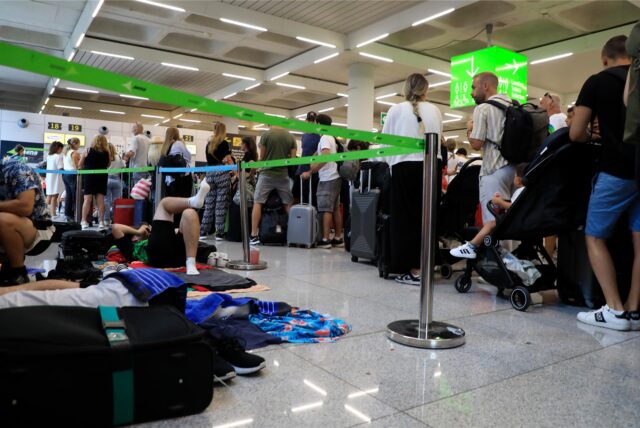 Reisende stehen im Flughafen von Palma de Mallorca Schlange.