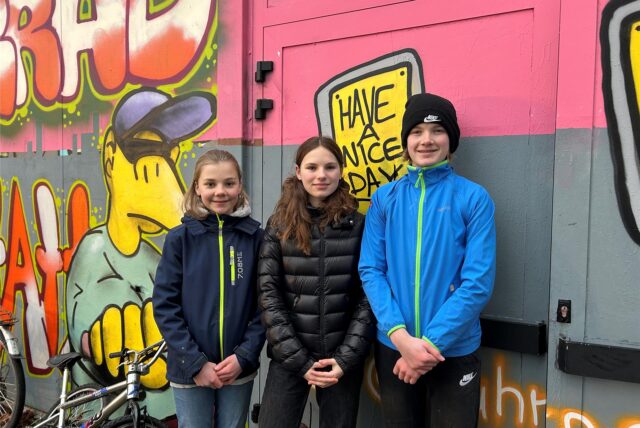 Drei Jugendliche, zwei Mädchen und ein Junge, stehen vor einer mit Graffiti verzierten Wand im Hinterhof des Jugendcafés Yahoo in Waltrop.