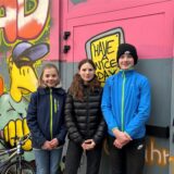 Drei Jugendliche, zwei Mädchen und ein Junge, stehen vor einer mit Graffiti verzierten Wand im Hinterhof des Jugendcafés Yahoo in Waltrop.