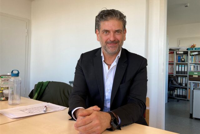 Andreas Wesche sitzt an einem Tisch.