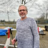 Christian Barz stellt mit seinem Unternehmen Herne Protect Trucksperren her. Im Hintergrund steht eine rot-weiße Trucksperre, die aus zusammengebauten Metallteilen besteht.