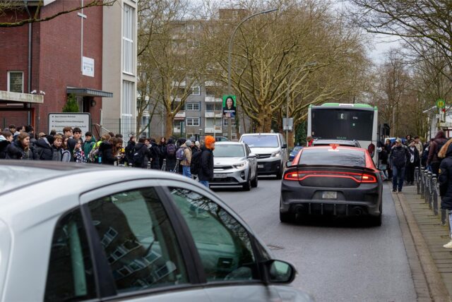 Schüler inmitten fahrender Autos auf der Dörwerstraße in Dortmund-Nette.