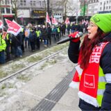 Mitarbeiter der hannoverschen Verkehrsbetrieben „Üstra“ laufen während eines Warnstreiks an einer Haltestelle vorbei.