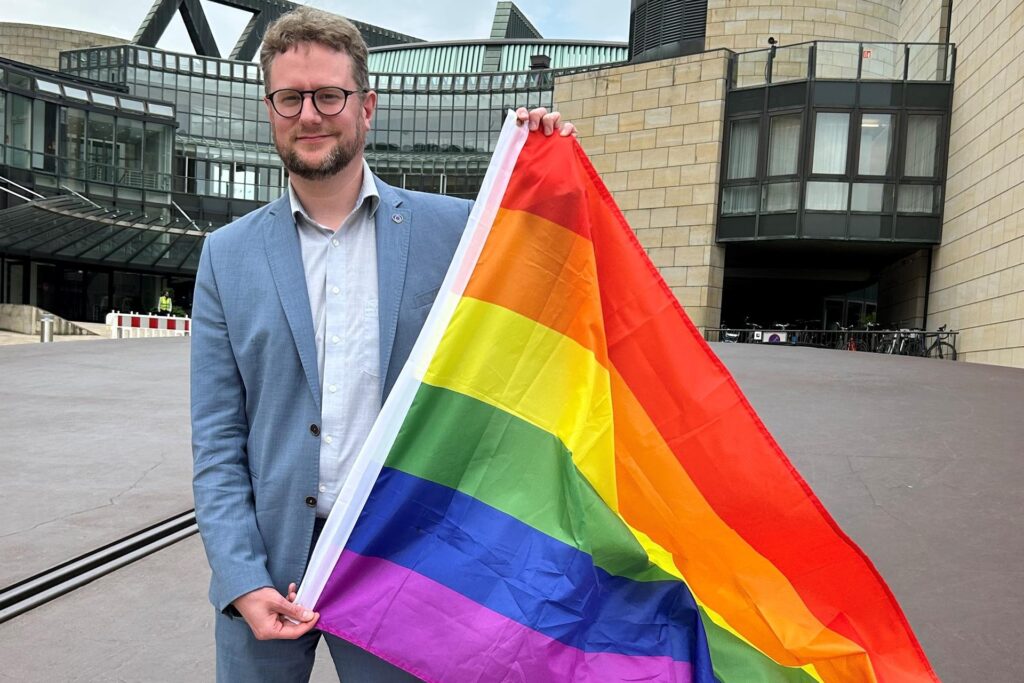 Jan Matzoll von den Recklinghäuser Grünen hält eine Regenbogenflagge in den Händen. Jan Matzoll von den Recklinghäuser Grünen hält eine Regenbogenflagge in den Händen.