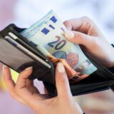 Nahaufnahme von zwei Händen, die Geldscheine aus einem Portemonnaie hervorholen.