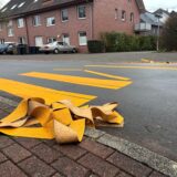 Kaputtes Knäule aus gelber Straßenmarkierungs-Folie an einem Zebrastreifen