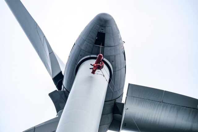 Ein Höhenretter der Feuerwehr schwebt, an Seilen sichert, beim Einsatztraining am Windrad auf der Hertener Halde Hoppenbruch direkt unter der Turbine.
