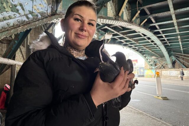 Tierschützerin Luzi Wilts hält Tauben in der Hand und steht unter der Eisenbahnbrücke am Burgtor.