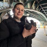 Tierschützerin Luzi Wilts hält Tauben in der Hand und steht unter der Eisenbahnbrücke am Burgtor.